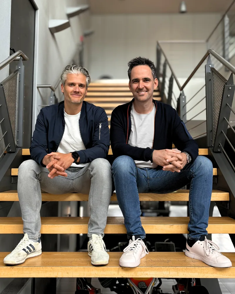 Die Gründer Tim Hochgreef und Patrick Schröder sitzen auf einer Treppe
